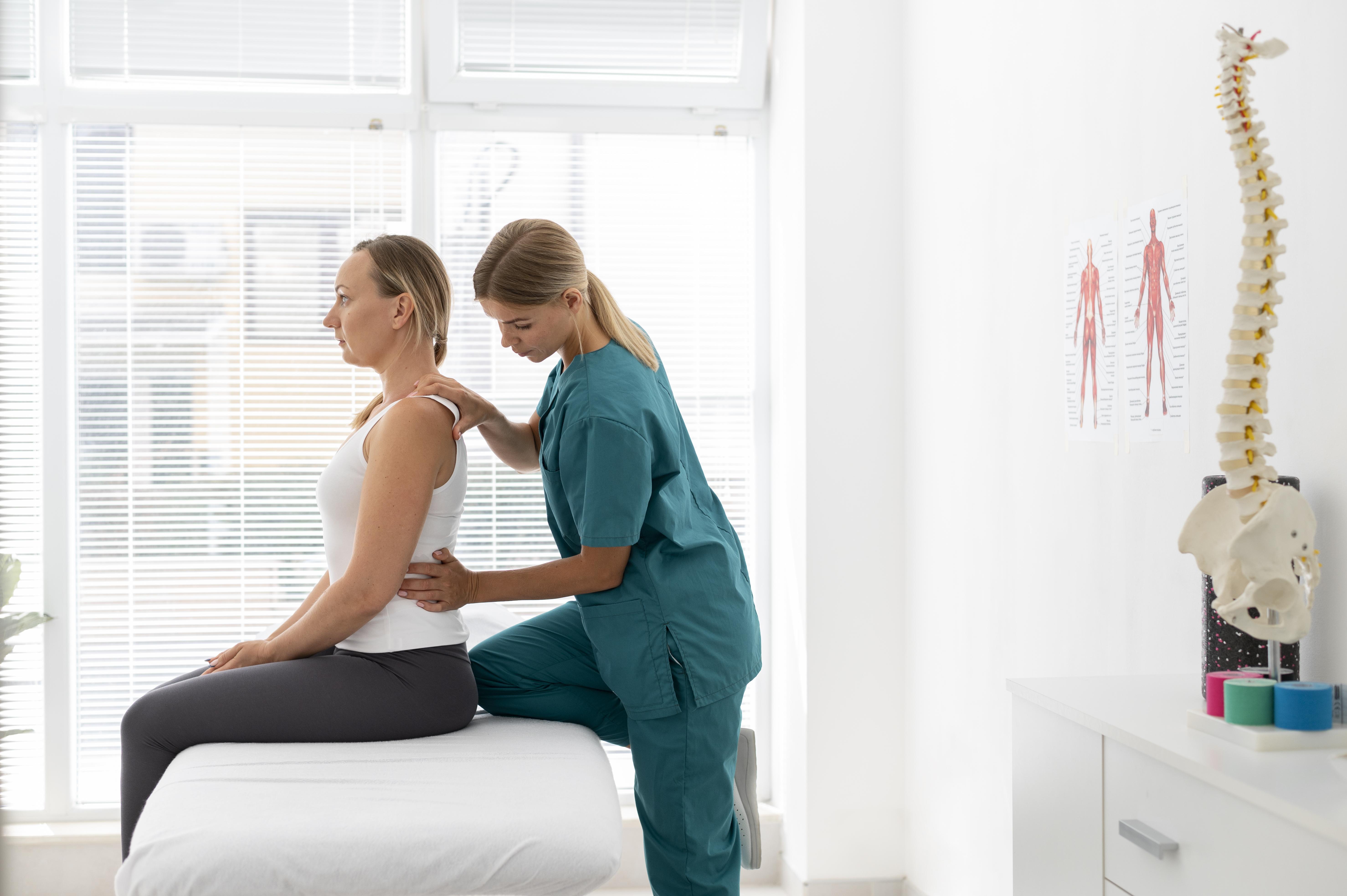 young-physiotherapist-helping-patient-with-back-problems - Hope Wellness